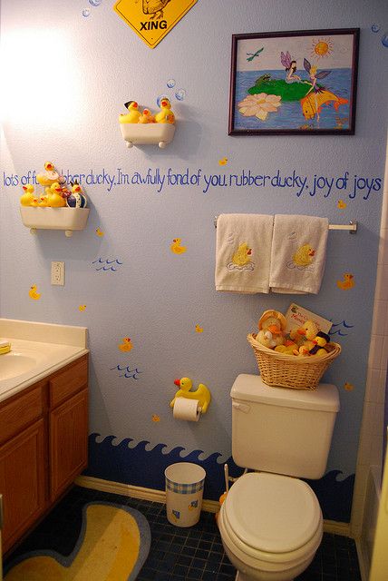 a bathroom decorated in blue and yellow with winnie the pooh wall decals on the walls