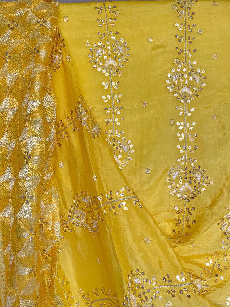 This elegant traditional Yellow Gold Bridal Phulkari Dupatta is expertly crafted from Pure Chinon Silk, with Gotta Patti and phulkari hand embroidery all over. The perfect choice for weddings, sangeet, jaago, and chunni ceremonies. Material: Pure silk chinon Work: Silk thread phulkari handwork, needlework, gotta patti work Pattern: Floral Size: Full Size 2.5 meters Dispatched in 1-3 business days Product Note:​ This is a handcrafted product from artisans and producer groups and due to the nature Yellow Chikankari Embroidery Dupatta For Transitional Season, Yellow Silk Dupatta With Chikankari Embroidery, Festive Yellow Meenakari Dupatta, Yellow Chikankari Embroidery Dupatta In Chinon, Phulkari Pants, Yellow Phulkari Dupatta, Phulkari Dupatta, Bridal Dupatta, Velvet Shawl