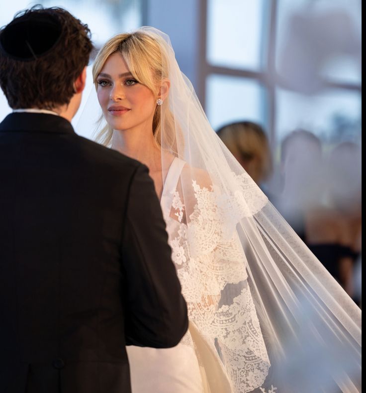 a woman in a wedding dress standing next to a man