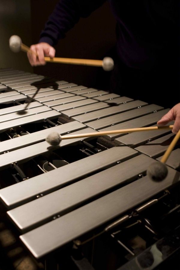 two hands holding mallets over an oven door with balls on the top and bottom