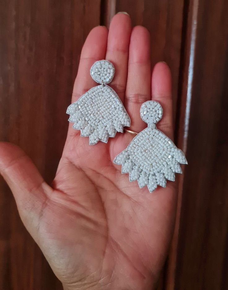 Handmade white beaded flower bridal earrings. The stunning pair of floral bridal earrings are hand-embroidered of white tiny seed beads. These are light weight and ideal option for the Brides. Earrings measure approx. 2.10" long and 1.75" wide. At Carnation jewellery, each piece is artisan handcrafted with love and care and shipped from India.  * SHIPPING - Please refer to the "announcement" page of the store. * Please be noted all kind of taxes, custom duties, VAT etc will be borne by the buyer as I am not responsible for the same. * For queries, please reach out to me and I shall revert ASAP. * PLEASE READ CAREFULLY THE SHOP ANNOUNCEMENT. Back to the store https://www.etsy.com/your/shops/ Carnation jewellery Sparkling Flower Drop Earrings For Wedding, Sparkling Drop Flower Earrings For Wedding, White Crystal Embellished Bridal Earrings For Wedding, White Crystal Embellished Wedding Earrings, Elegant White Crystal Flower Earrings, White Crystal Embellished Jewelry, White Crystal Embellished Bridal Earrings For Party, White Crystal Flower Earrings For Party, White Crystal Embellished Earrings For Party