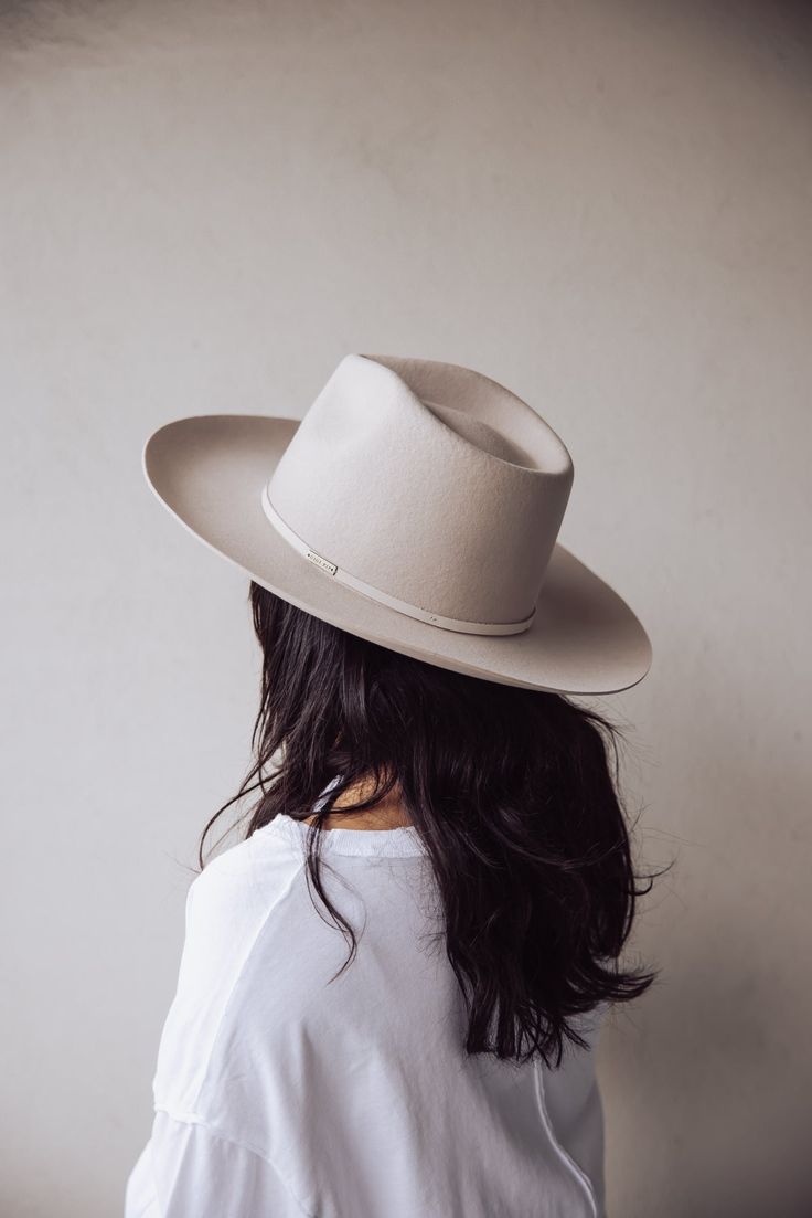 FEDORA Details: 100% Australian wool. Pinched fedora crown. Stiff wide slightly upturned brim. Tall crown height. Great sun protection. The Rowan is a fedora re-imagined. We've redesigned it with a taller crown + wider brim for a more dramatic take on a classic + timeless style. Featuring an attached genuine leather band, this hat is a statement piece on it's own. Cream Felt Hat With Flat Crown For Summer, Beige Fedora With Flat Brim For Fall, Beige Flat Brim Fedora For Fall, Beige Curved Brim Panama Hat For Everyday, Fitted Beige Fedora With Flat Brim, Beige Short Brim Fedora For Everyday, Elegant Hats With Short Brim Unlined, Classic Beige Panama Hat For Fall, Elegant Unlined Hats With Short Brim