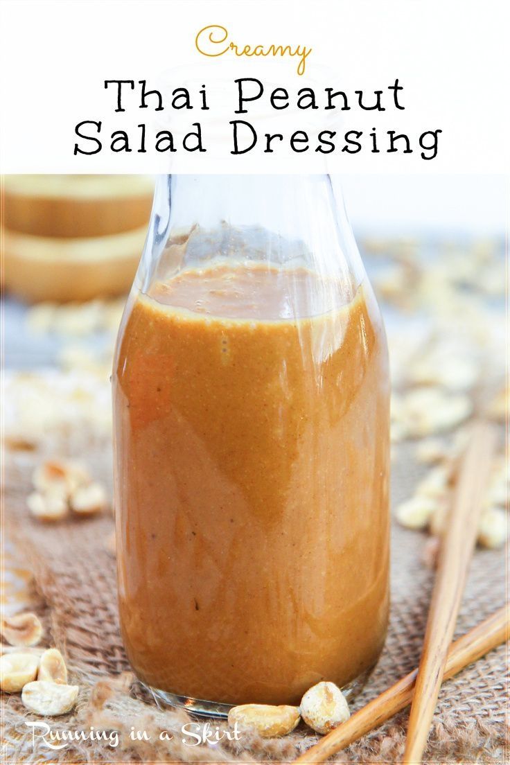 a jar filled with peanut butter next to two wooden spoons