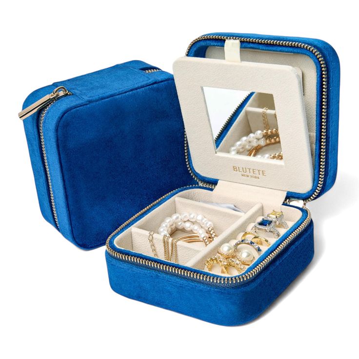 an open blue velvet jewelry box with two rings inside