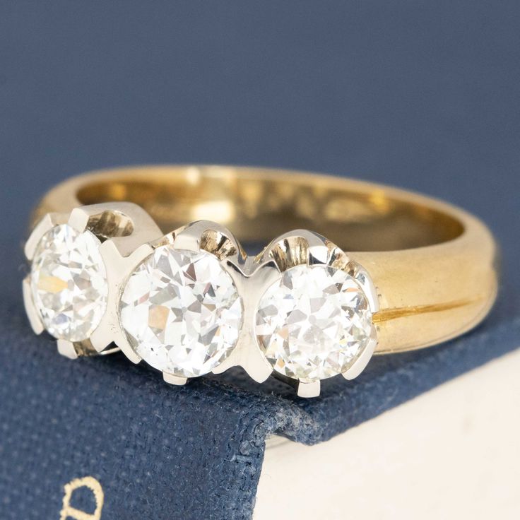 three stone diamond ring sitting on top of a book