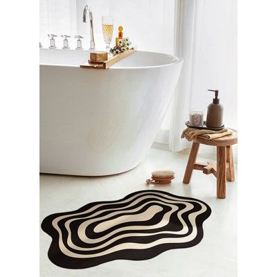 a bath room with a tub and a rug on the floor in front of it