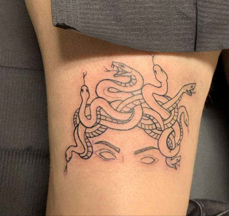 a woman's thigh with a snake tattoo on it