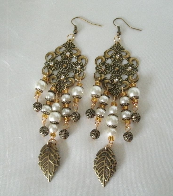 "Medieval Earrings These beautiful earrings have gold plated filigree settings, pearl beads, seed beads, rhinestones, antique gold leaf charms, gold plated filigree beads and gold plated bead caps. 4\" long from hook bottom." Elegant Brass Jewelry With Pearl Drop, Elegant Pearl Drop Brass Jewelry, Victorian Chandelier Earrings With Intricate Design, Victorian Chandelier Dangle Earrings With Intricate Design, Victorian Filigree Chandelier Dangle Earrings, Victorian Style Bronze Pierced Earrings, Victorian Bronze Pierced Earrings, Victorian Chandelier Drop Earrings With Intricate Design, Victorian Drop Earrings For Pierced Ears