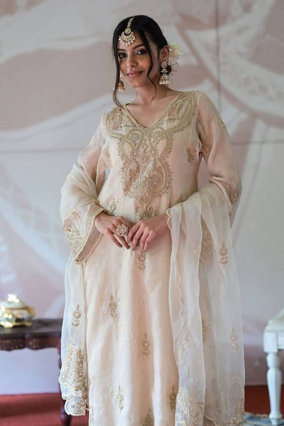 Ivory and beige kurta with pearl and cutdana embroidery and cutout details in the back. Paired with a silk palazzo, inner and organza embroidered dupatta. - Aza Fashions Festive Organza Palazzo Set With Intricate Embroidery, Elegant Palazzo Set With Sheer Dupatta For Reception, Elegant Palazzo Set For Reception With Sheer Dupatta, Elegant Off White Raw Silk Sets, Unstitched Organza Palazzo Set For Reception, Elegant Palazzo Set With Dabka Work For Reception, Elegant Dabka Work Palazzo Set For Reception, Beige Organza Sets With Intricate Embroidery, Organza Palazzo Set With Chikankari Embroidery For Receptions