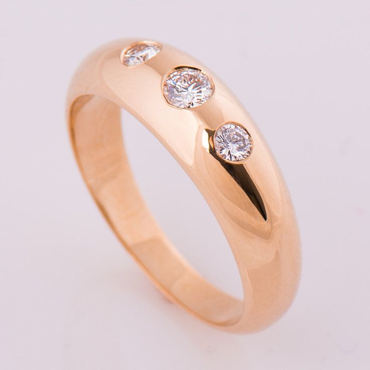 a gold ring with three diamonds on it