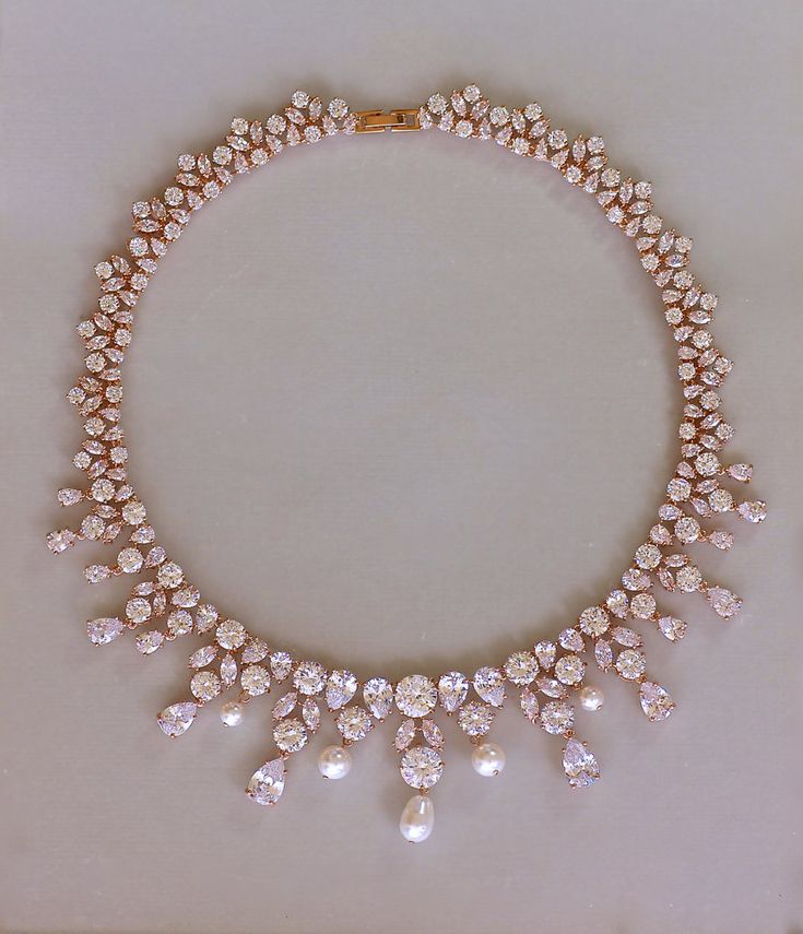 "This stunning rose gold necklace has been designed with marquise, round and teardrop crystal zircons creating a statement necklace in true Hollywood style. Juliette is perfect for strapless style dresses and is beautifully flattering and sure to wow! We have featured Ivory white Swarovski teardrop pearls to coordinate with your wedding dress. Customize by choosing from our extensive pearl selection. Also available in an all crystal style. Teardrop crystals replace the pearls. 💜 Available in ro Bridal Statement Necklace, Gold Crystal Necklace, Rose Gold Crystal, Diamond Jewelry Necklace, Diamond Jewelry Designs, Gold Jewellery Design Necklaces, Gold Jewelry Necklace, Wedding Etsy, Gold Necklace Designs