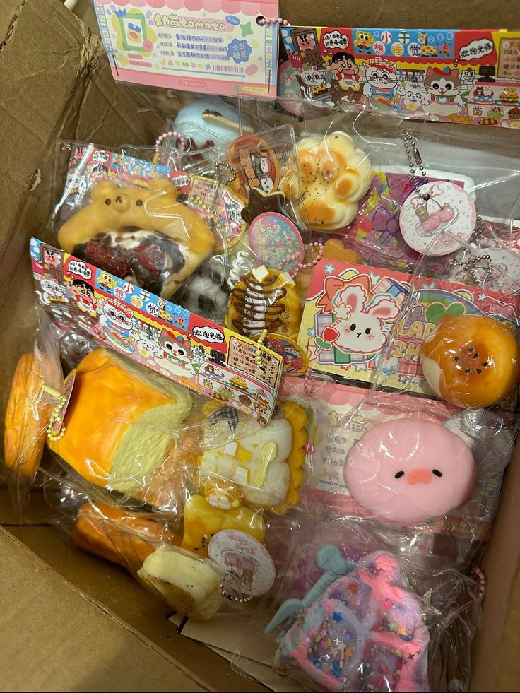 an open box filled with assorted toys and other items in plastic wrap around it