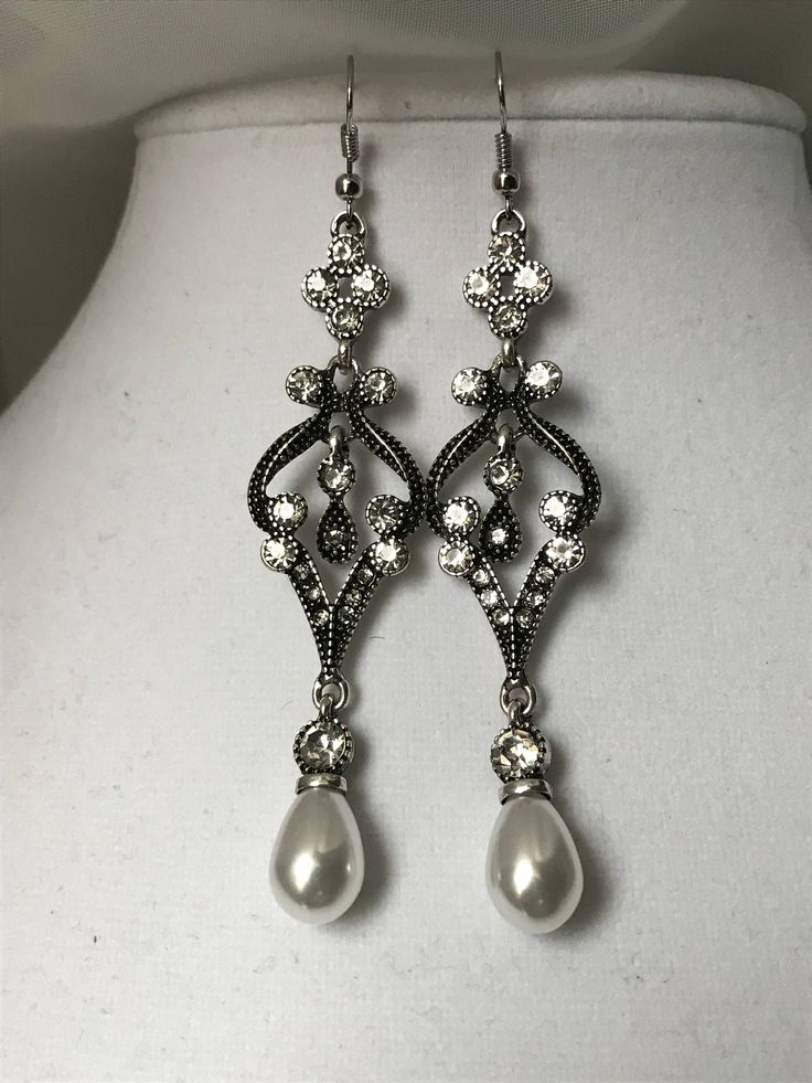 Silver pearl/clear crystal drop earrings. Measuring about 3inches If you have any questions please don't hesitate to ask Vintage Earrings Silver, Evening Crystal Pearl Drop Earrings, Evening Pearl Drop Crystal Earrings, Elegant Silver Crystal Earrings With Pearl Drop, Wedding Crystal Pearl Drop Earrings, Glamorous Pearl Drop Dangle Bridal Earrings, Formal Pearl Embellished Drop Chandelier Earrings, Formal Pearl Embellished Chandelier Drop Earrings, Vintage Metal Pearl Earrings For Wedding