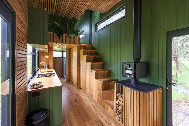 the interior of a house with green walls and wooden stairs leading up to an open floor plan