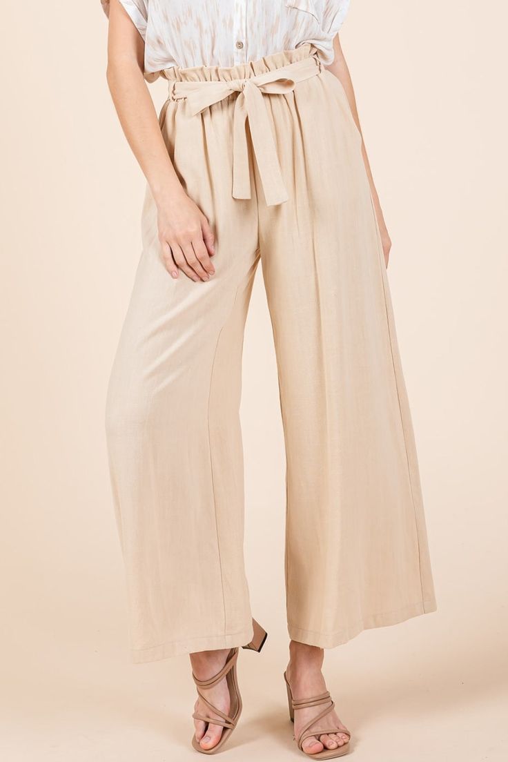 High Waist Tie Front Wide Leg Pants are a stylish and flattering bottom option that features a high waist and wide legs with a tie-front detail. The high waist design accentuates the waistline and creates a long and lean silhouette. The wide legs offer a flowy and relaxed fit, providing comfort and a chic look. The tie-front detail adds a fashionable touch, allowing you to cinch the waist for a customized and flattering fit. These pants can be dressed up with a blouse and heels for a sophisticat Elegant Loungewear Pants With Tie Waist, Linen Tie Waist Pants For Work, Chic High-waisted Culottes, Workwear Linen Pants With Tie Waist, Loungewear Ankle-length Pants With Tie Waist, Chic Paperbag Waist Bottoms For Workwear, Casual Wide Leg Pants With Tie Waist, Chic Loungewear Pants With Tie Waist, Chic Solid Color Wide-leg Pants