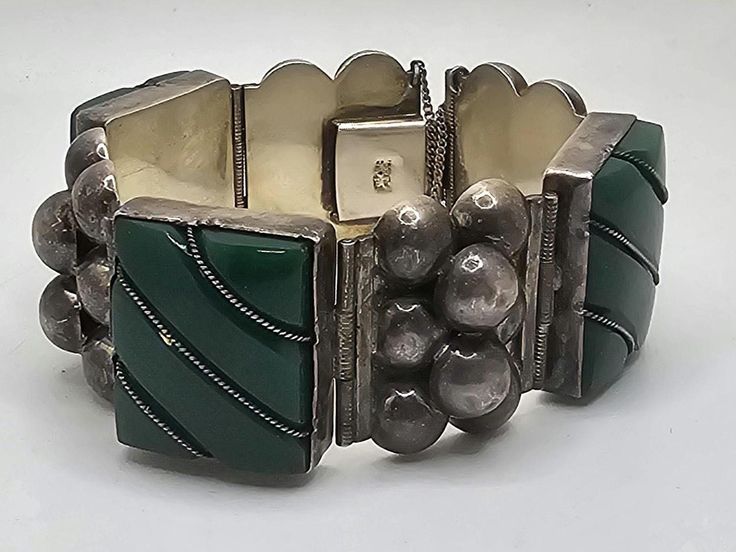 This is a very rare 1940's Mexican Sterling Silver warrior bracelet. The stones are a green Onyx and are all set tightly in there settings. The bracelet is very clean and has a gorgeous patina evenly covering the entire piece. This bracelet has a few imperfections shown in the pictures. The safety chain is intact and the clasp works as good as the day it was made. Satisfaction Guaranteed Green Bangle For Collectible Jewelry, Vintage Green Bracelet With Patina, Green Bangle Jewelry Collectible, Green Bangle Collectible Jewelry, Vintage Green Bangle Jewelry, Handmade Antique Green Bracelet, Antique Green Handmade Bracelet, Art Deco Green Bracelet For Formal Occasions, Art Deco Green Bracelets For Formal Occasions