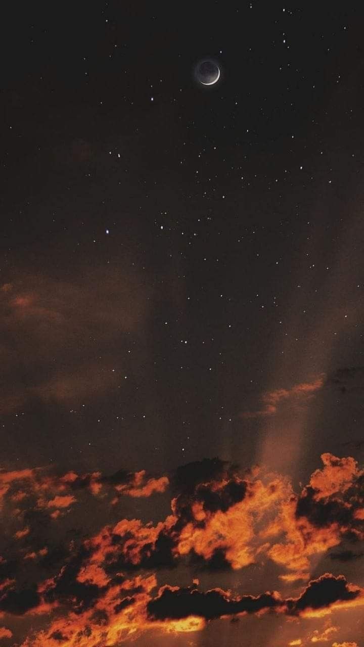 the sky is filled with stars and clouds as the moon shines in the distance