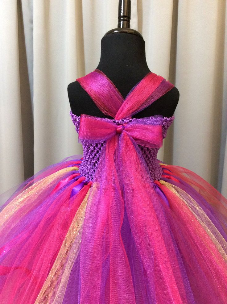 Fuzzy Duckling Design dresses ~ handcrafted for the little princess in your life. Our beautiful dresses feature a stretchy, crocheted bodice that is fully lined for both comfort and modesty. The full skirts sparkle and shine with three layers of high quality tulle in matte, shimmer, and glitter finishes. Satin ribbons and jewels are added to make each dress something special. She'll feel like a fairy princess when wearing her matching accessories. This dress includes a matching sparkly ribbon cr Pink Fairytale Princess Dress For Party, Whimsical Tulle Princess Dress, Fairy Style Pink Dress For Birthday, Fairy Style Pink Princess Dress For Birthdays, Fairytale Tulle Fairy Dress For Party, Pink Fairytale Fairy Dress For Party, Pink Fairy Dress For Birthday, Fitted Princess Tutu Dress In Glitter Tulle, Fairycore Tulle Dress For Costume Party