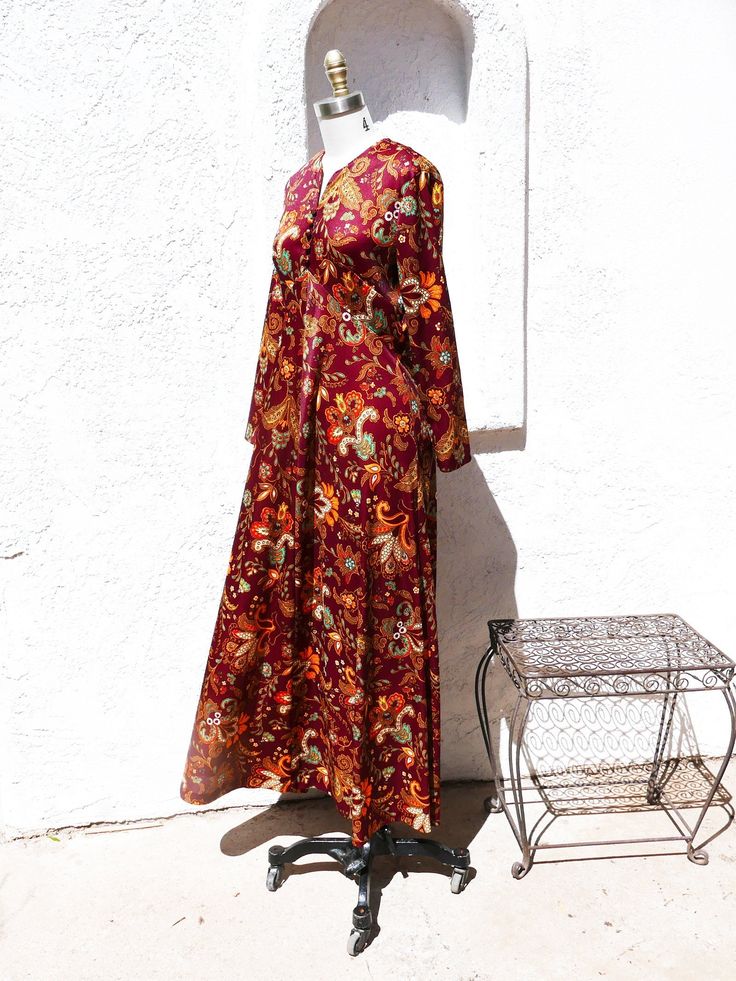 Long brown polyester dress with a large, beautiful paisley all over print. This classic long sleeve maxi hippie dress would be perfect for a 60's party or festival. It has long sleeves, and is cut on the bias so the skirt flows. There are covered buttons in the front and a metal zipper closure in the back. Fits up to a current size 8 Measurements with room for comfort Bust up to 36 inches Waist up to 29 inches Hips up to 39 inches Exact measurements taken flat to compare to a garment you own Len Fall Paisley Print Maxi Dress With V-neck, Brown Long Sleeve Dress With Paisley Print, Casual Brown Long Sleeve Dress With Paisley Print, Long Sleeve Printed Dresses For Festival, Printed Long Sleeve Dress For Festival, Printed Long Sleeve Festival Dresses, Brown Printed Long Sleeve Maxi Dress, Printed Long Sleeve Brown Maxi Dress, Brown Long Sleeve Printed Maxi Dress