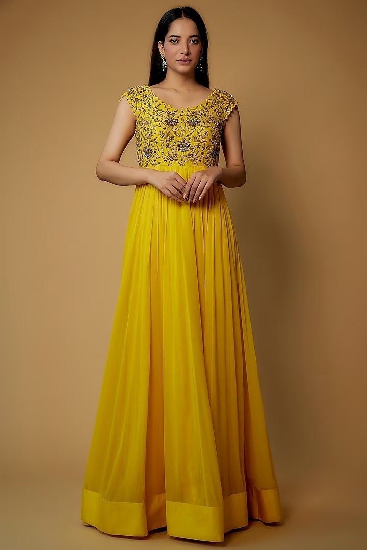 Featuring a yellow dress in dola silk, cotton, shantoon, and georgette base with embroidery. Perfect wear for festive occasions. This product will be shipped to you after 1-2 weeks from the date of order placed. All custom made orders are not returnable. Pls contact for Size chart and for other more colors Request You :To provide contact details for courier services. {VARIATION MAY COME DEPENDING UPON AVALIBILITY OF LACES OR GOTTA PATI or TUSSELS} NOTE:  1) Visual Samples on website may differ slightly from actual product due to light & effects during photography (Length & Breadth have 1 n 1.5 inches +/-). 2) Before placing order ,pls confirm product n color availability and  For Wholesale Order MOQ is 5 Pieces of any color/Pattern on +91 7903893945 & +91 8447750028(WhatsApp) Bridal lehang Gold Embellished Chanderi Dress, Yellow Semi-stitched Dresses With Zari Work, Designer Gold Georgette Dresses, Yellow Chanderi Dress With Resham Embroidery, Yellow Embroidered Chanderi Dress, Gold Georgette Dresses With Chikankari Embroidery, Yellow Anarkali Set With Chikankari Embroidery For Reception, Yellow Embroidered Dresses For Diwali, Elegant Yellow Dress With Zari Work