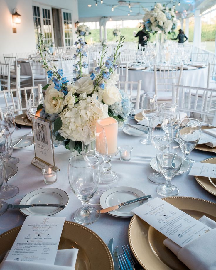 the table is set with white and blue flowers