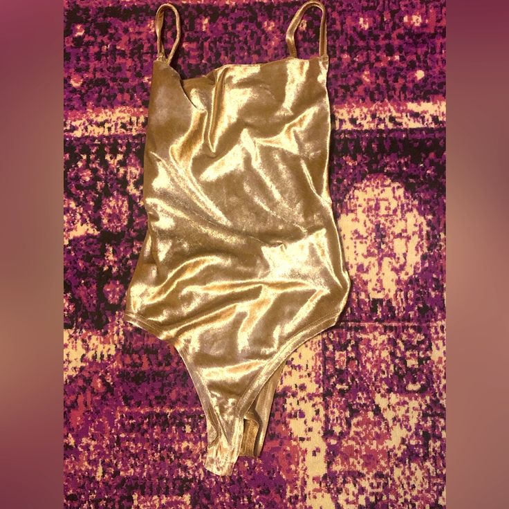 Adjustable Straps Open Back Smooth Velvet Gold Stretch Bodysuit For Summer, Gold One-piece Bodysuit For Beachwear, Gold Stretch Sleeveless Bodysuit, Gold Bodysuit For Night Out, Fitted Gold Bodysuit For Beach, Metallic Fitted Bodysuit For Summer, Gold Lined Swimwear For Party, Gold Fitted Sleeveless Swimwear, Fitted Sleeveless Gold Swimwear