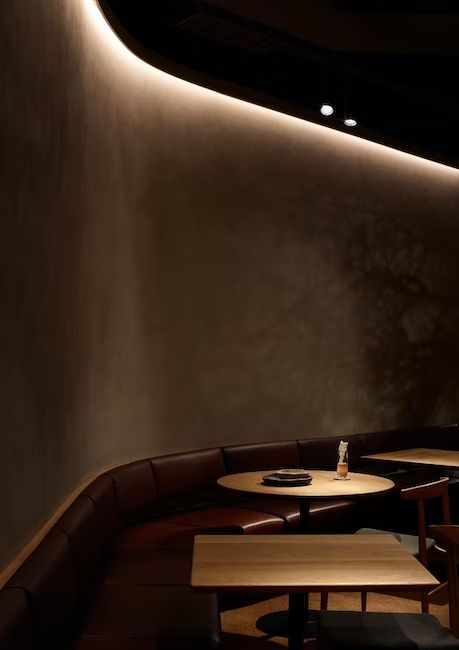 a dimly lit restaurant with wooden tables and benches