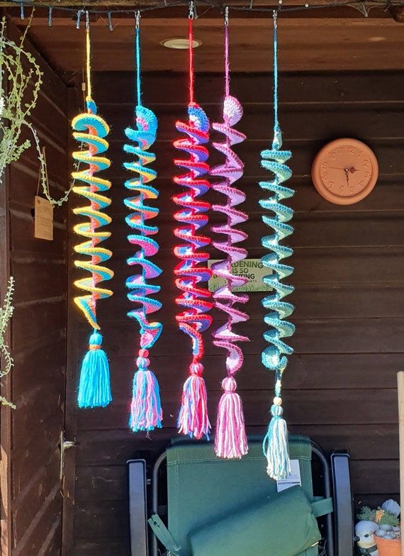 colorful wind chimes hanging from the side of a building