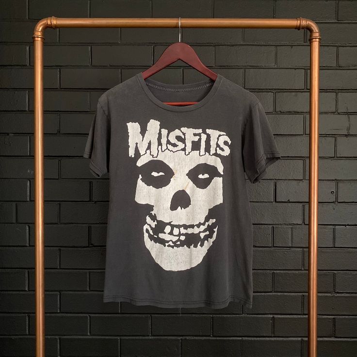 VINTAGE :: 90s MISFITS Skull Tee  COLOUR :: Black  FIT/TAG :: S MATERIAL :: Cotton  CONDITION :: Excellent   MEASUREMENTS ::  Armpit to Armpit Width - 46cm // 18"   Total Length CB Neck to Bottom - 58.5cm // 23"   Arm Length from Shoulder Seam to Sleeve Edge - 16.5cm // 6.5"    DETAILS :: Perfectly worn in preloved Misfits Skull Tee. Front Print Only. Soft feel, excellent condition. Cracked print. Small amber marks on front seen in images. NOTE :: Each hand selected vintage or preloved piece is Acid Wash Skull Print Top For Streetwear, Grunge Band Logo Tops For Halloween, Grunge Tops With Band Logo For Halloween, Vintage Cotton Tops With Skull Print, Vintage Distressed Tops For Halloween, Vintage Distressed Halloween T-shirt, Acid Wash Skull Print Top For Halloween, Halloween Acid Wash Skull Print Top, Distressed Skull Top In Punk Style