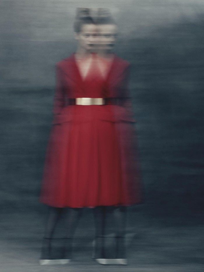 a woman in a red dress standing with her back to the camera