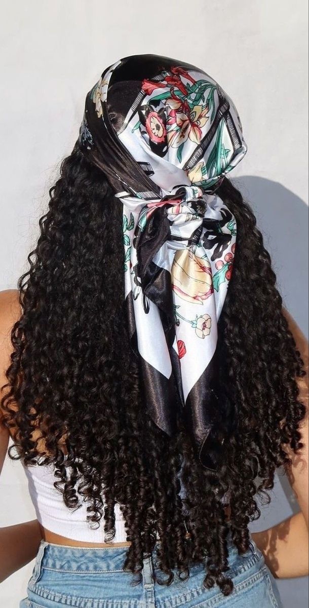 a woman with long curly hair wearing a scarf