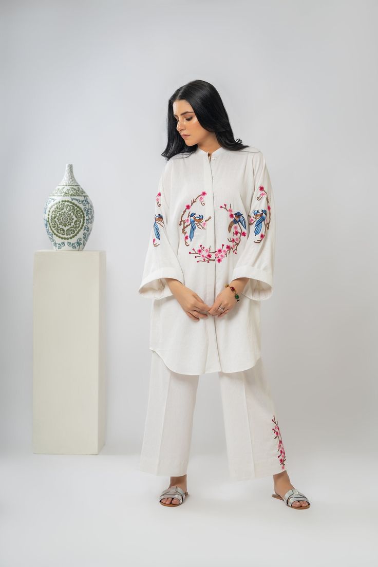 Intricate embroidery, buttoned down shirt and cropped lose pants. Perfect blend of comfort and style for any occasion.  -Premium Irish Cotton  -Buttoned down oversize shirt with cropped lose pants -Oversize dropped shoulder embroidered sleeves  -Hand-Machine Embroidered  -cropped lose pants with embroidery  -Adjustable pant with elastic at back for comfort  -Hanging loop for your ease -Hand wash only Spring Workwear Kurta With Resham Embroidery, Spring Resham Embroidery Kurta For Workwear, Embroidered Straight Pant Set For Spring, Embroidered Straight Pants Set For Spring, Spring Embroidered Straight Pant Set, Spring Floral Embroidered Long Sleeve Pant Set, Spring Floral Embroidery Long Sleeve Pant Set, Embroidered Straight Pant Set For Office, Embroidered Straight Pant Set For Work