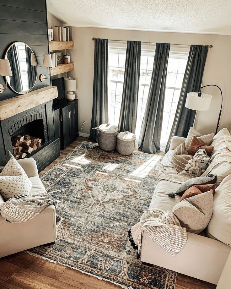 a living room filled with furniture and a fire place in front of a mirror on the wall