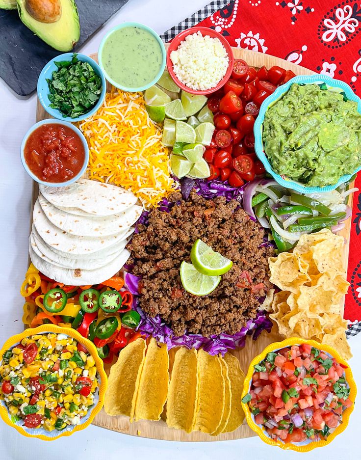 a platter filled with tacos, tortillas and guacamole