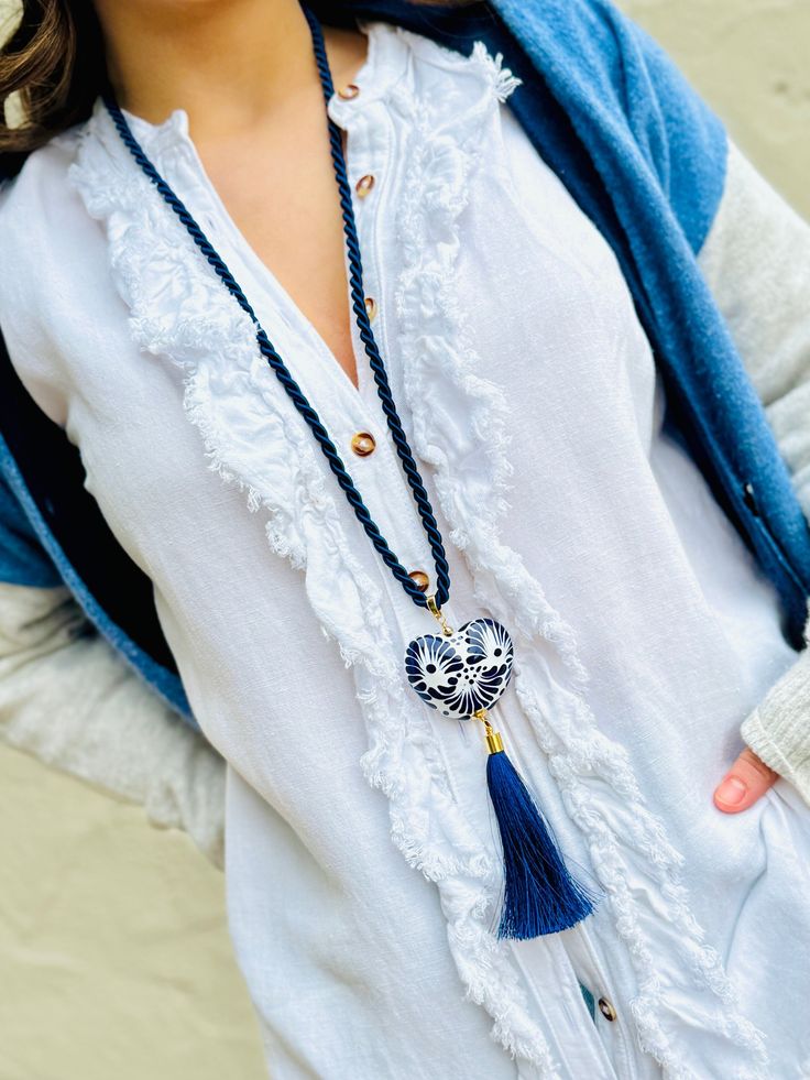 Dive into the boho-chic vibe with our captivating Boho Necklace, featuring a stunning Corazon Mexicano in blue and white made of the finest talavera mexicana. This unique piece captures the heart of Mexican artistry, giving you a slice of authentic talavera pottery to adorn your outfits. Hanging gracefully from a long, silky blue cord, the ceramic pendant is the centerpiece of this bohemian dream. It's not just any pendant; it's a burst of Mexican culture wrapped up in a jewelry piece. And let's Artisan Blue Jewelry For The Beach, Artisan Blue Jewelry For Beach, Traditional Blue Jewelry For Beach, Traditional Blue Beach Jewelry, Blue Bohemian Necklace, Blue Bohemian Necklaces For Vacation, Blue Tassel Necklace, Traditional Blue Necklaces For Beach, Bohemian Blue Necklace