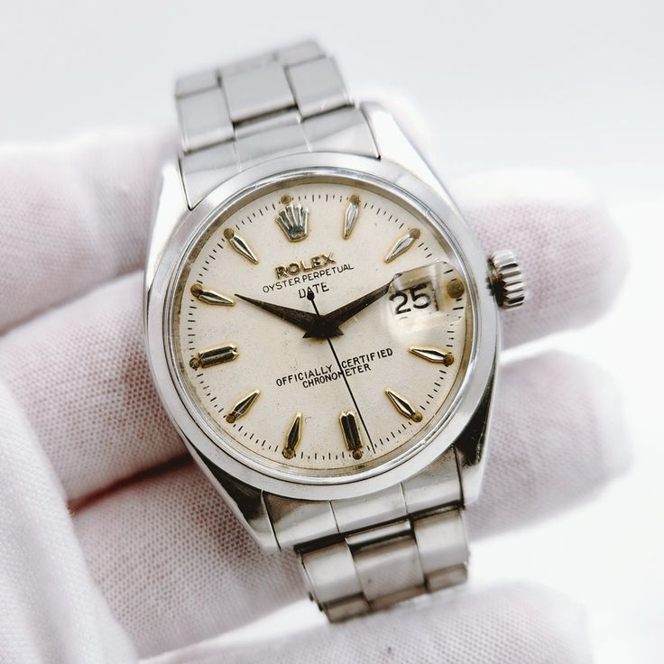 Men's Rolex 34mm Date Vintage Stainless Steel Watch with Cream Dial and Smooth Bezel. Pre-Owned SN# 485**** Year: 1976. Brand: Rolex. Crystal: Plastic. Gender: Men's. Case Back: Solid. Dial Color: Silver Dial. Condition: Very Good. Model Number: 6534. Case Dimensions: 34mm. Metal Type: Stainless Steel. Bezel Color: Stainless Steel. Model: Oyster Perpetual Date. Bracelet / Strap: Stainless Steel. Movement: Mechanical (Automatic). Box / Certificate: Rolex Box / Certificate of Authenticity. Service Warranty: One (1) Year Limited Service Warranty. Rolex Day Date Vintage, Men's Rolex, Date Bracelet, Patek Philippe Mens, Rolex 5513 Vintage, Rolex 1908, Stainless Steel Rolex, Coach Watch, Rolex 5513