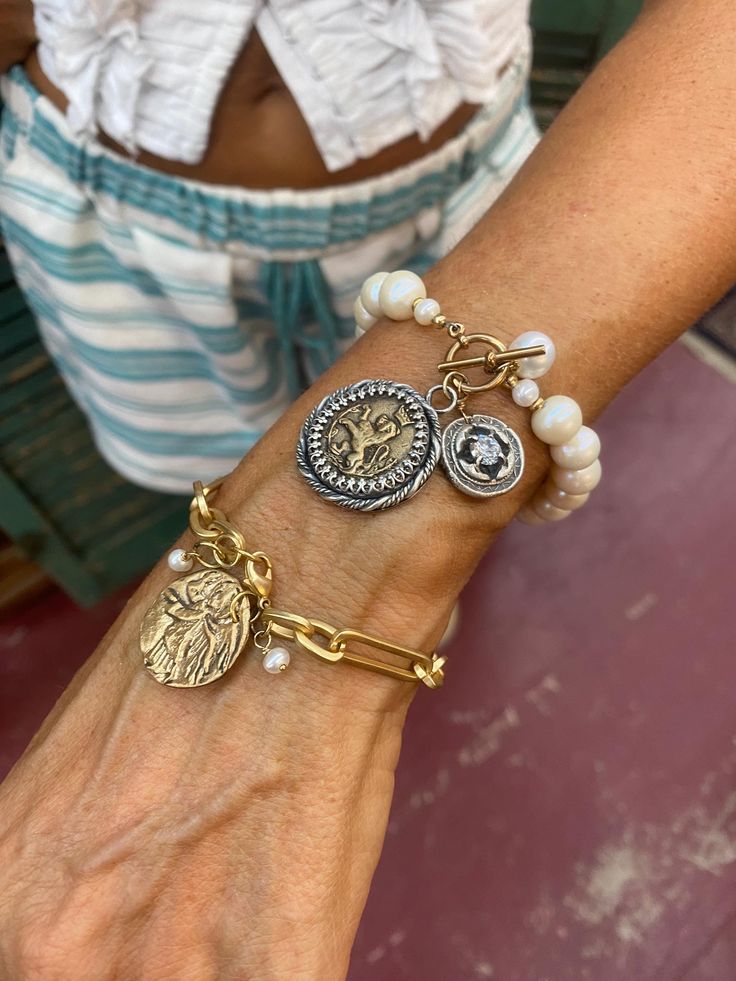 This listing is for a : Your choice: Modeled by Angelia,  one of our beautiful owners... # 59 Is a beautiful French Inspired bracelet, with Fresh Water Pearls, Sterling and Bronze Lion Charm, and Sterling and white topaz charm with a toggle brass closure.  It is 7.5"  and not adjustable . If you need a different size, please contact us before purchasing. # 60 Is a Religious Inspired Brass Electroplated and clear coated paper clip chain bracelet with a Bronze Angel Charm and tiny pearl drop. This Luxury Adjustable Bracelets With Charms, Luxury Adjustable Charms Bracelets, Luxury Adjustable Charms Jewelry, Bohemian Pearl Bracelet For Jewelry Making, White Round Jewelry With Bracelet Strap, White Jewelry With Round Bracelet Strap, Luxury Beaded Bracelet Jewelry, Luxury Beaded Jewelry Bracelet, Silver Bangle Bracelet With Pearl Charm