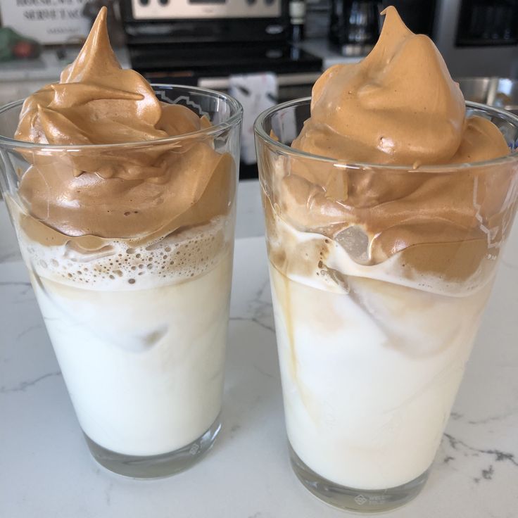 two glasses filled with ice cream on top of a counter