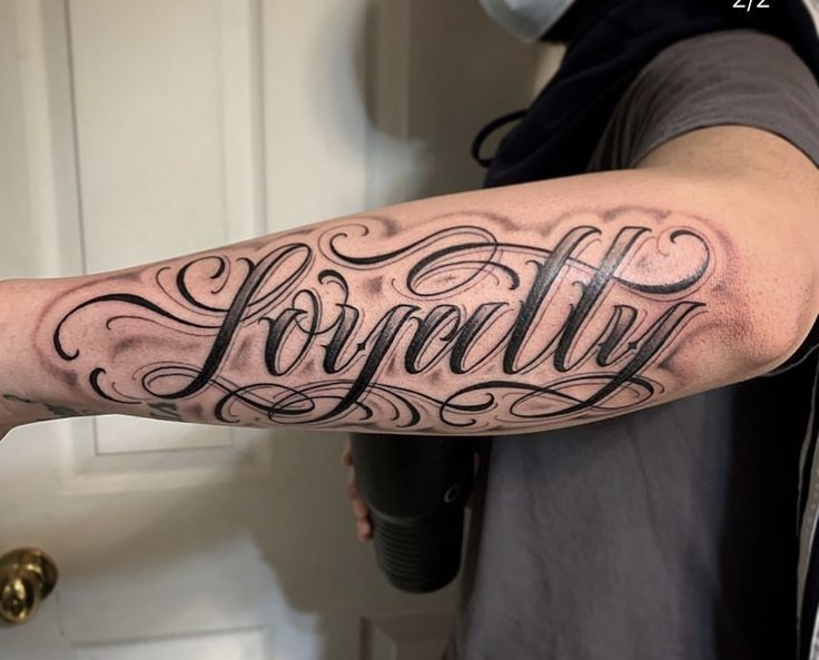 a man with a tattoo on his arm that says, londly in cursive writing