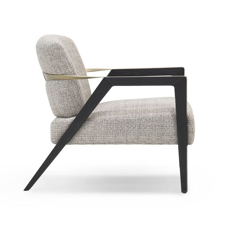 a modern chair with a black frame and gold trim on the arm, sitting against a white background