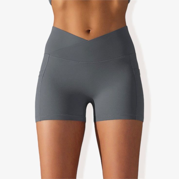 The Anna-Kaci Women's V-Cross Front Wide Band Biker Shorts are a stylish and functional addition to your activewear collection. These yoga shorts feature a unique V-cross front wide band for a secure and flattering fit. Made with 4-way stretch fabric, they offer maximum flexibility and comfort during any activity. The side pocket detail provides practical storage for essentials, while the side panel design adds a trendy touch. Perfect for yoga, workouts, or casual wear, these biker shorts combin Functional Yoga Pants With Built-in Shorts For Sports, Versatile Activewear With Built-in Shorts For Outdoor, Versatile Activewear With Built-in Shorts For Outdoor Activities, High Stretch Sports Shorts With Pockets, High Stretch Short Activewear With Pockets, High Stretch Activewear Shorts With Pockets, Short Length High Stretch Activewear With Pockets, Gray Athleisure Activewear With Built-in Shorts, Fitted Workout Shorts With Crossover Waistband