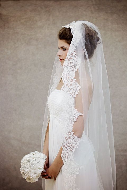 a woman wearing a wedding veil and holding a bouquet