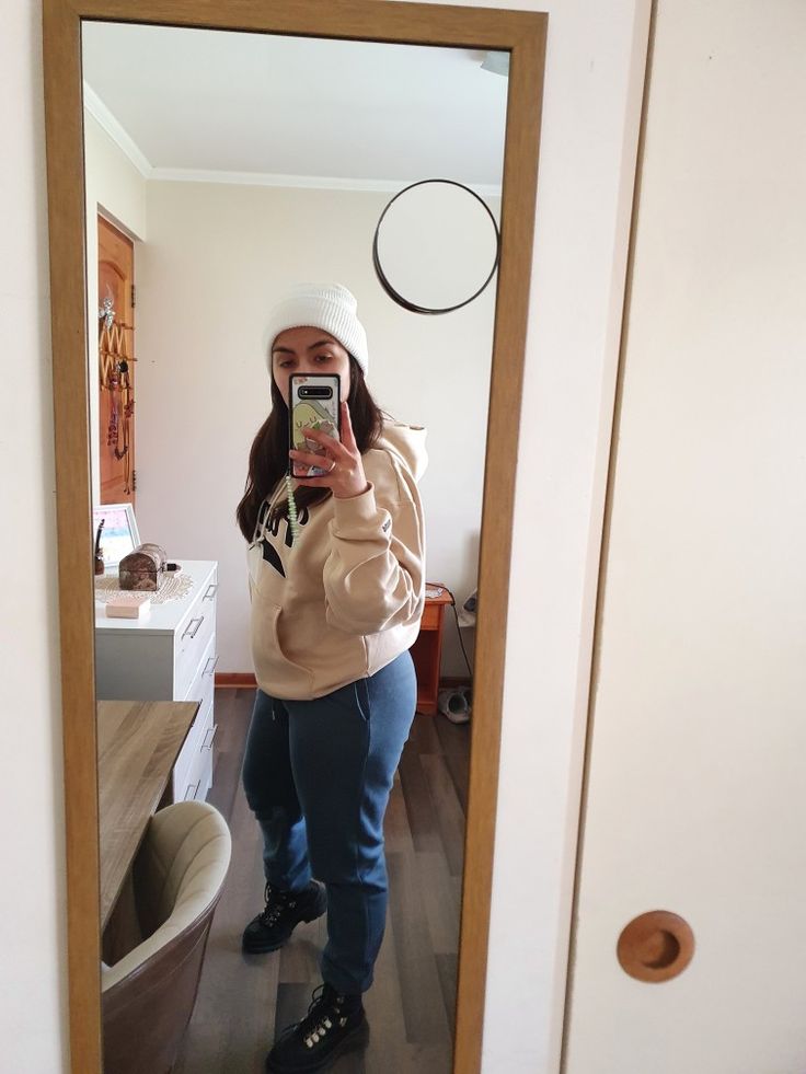 a woman taking a selfie in front of a bathroom mirror with her cell phone