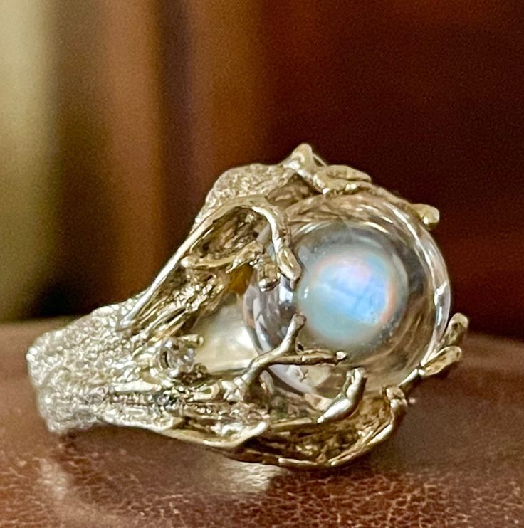 Rare vintage Modernist /BRUTALIST HUGE POOLS OF LIGHT ROCK CRYSTAL GLASS ORB Heavy Ring! in excellent condition! arrives in jewelry case and can be gifted immediately! crafted in solid heavy sterling silver and  yellow gold  wash and set with paste stones like diamonds and big clear orb - pools of light! please see photo against window - it is absolutely transparent and clear! rare ring! piece of Art on your hand! since it is clear it plays with the light and reflects everything! size a little u Mystical Collectible Gemstone Rings, Mystical Gemstone Rings For Collectors, Gold Moonstone Ring Collectible, Collectible Gold Hallmarked Moonstone Ring, Vintage Gold Moonstone Ring For Anniversary, Vintage Gold Moonstone Anniversary Ring, Antique Gold Crystal Gemstone Ring, Mystical Cabochon Ring For Anniversary, Mystical Anniversary Ring With Cabochon