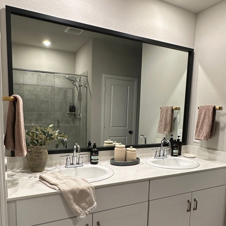 a bathroom with two sinks and a large mirror