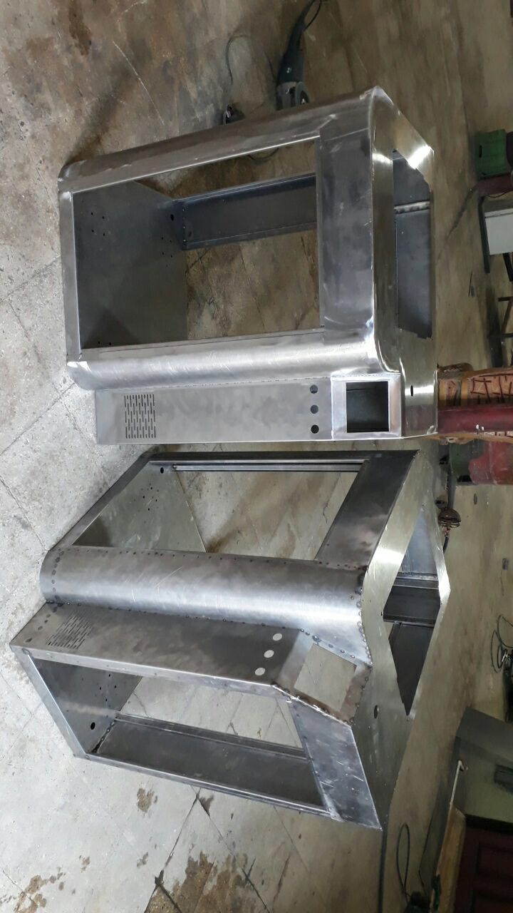 two stainless steel stoves sitting on top of each other in a room filled with tools