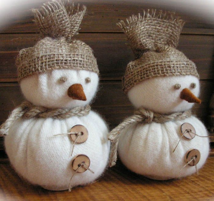 two white pumpkins with hats and buttons on them