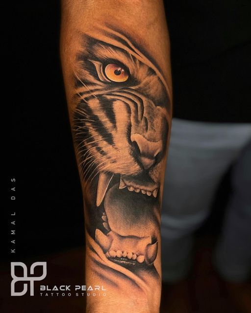 a man's arm with a tiger tattoo on it and an orange eye in the center