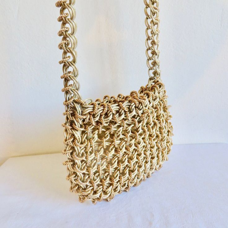 High end designer quality manufactured purse made of 2 kinds of thick gold interlocked chain. Rectangular shape and lined in gold metallic vinyl. Closure at the top consists of a small chain that connects to a metal hook. Shoulder strap is composed of 2 gold chains connected with the gold rings. **Ask me about International shipping rates. Label:  None.  I bought the purse from a woman who said she purchased it from a high end store in LA in 1969. Condition:  Excellent.  Looks barely used.  Inte Yellow Gold Rectangular Shoulder Bag With Gold-tone Hardware, Formal Gold Metal Shoulder Bag, Metallic Rectangular Shoulder Bag With Chain Strap, Rectangular Metal Shoulder Bag With Chain Strap, Yellow Gold Rectangular Shoulder Bag, Metallic Rectangular Bag With Chain Strap, Gold Chain Clutch Shoulder Bag, Chic Gold Metal Evening Bag, Metal Rectangular Evening Bag With Chain Strap