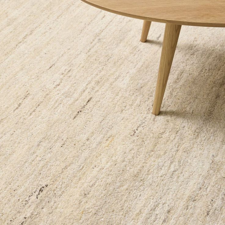 a coffee table sitting on top of a carpeted floor next to a wooden bench